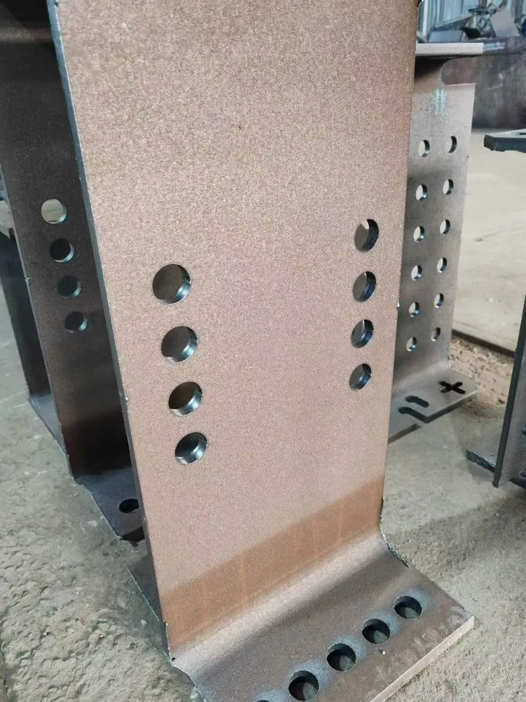 Two rows of laser cut bolt holes in an H-beam web